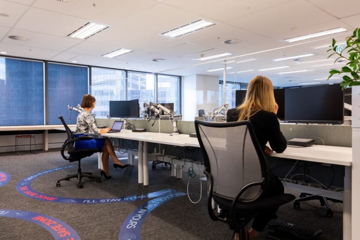 C&Wの提案する6フィートオフィス　床には距離を示す円形が、デスク前には飛沫防止のパネルが設置されている（シドニー/C&W提供）