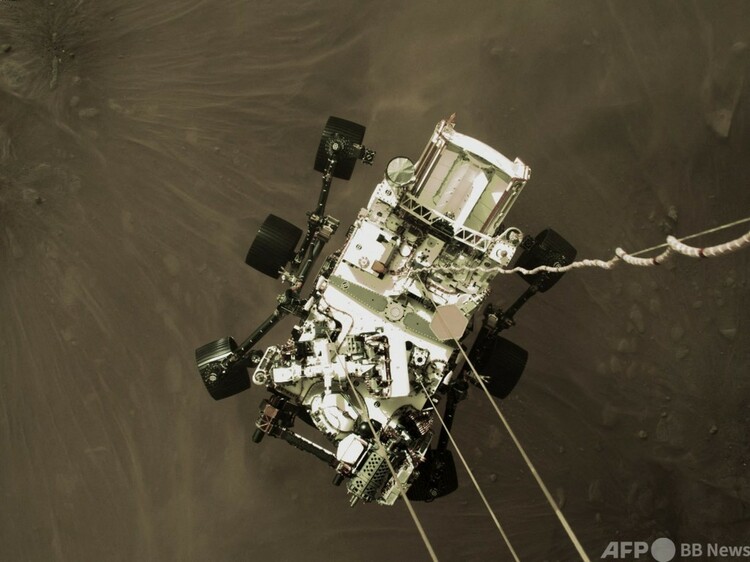 「スカイ・クレーン」で火星に降ろされる米航空宇宙局（NASA）の火星探査車「パーサビアランス」（2021年2月18日撮影）。(c)AFP PHOTO : NASA