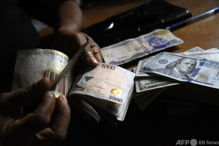 ナイジェリア・ラゴスで、ナイラ紙幣を数える男性（2021年4月19日撮影、資料写真）。(c)PIUS UTOMI EKPEI : AFP