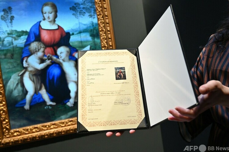 ラファエロ作「ひわの聖母」のデジタル再現画（左）。英ロンドンのギャラリー「ユニットロンドン」で開催中の「NFT（非代替性トークン）」アートの展覧会で（2022年2月15日撮影）。(c)JUSTIN TALLIS / AFP