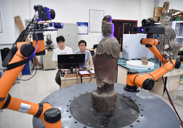「文化財外観情報急速収集モデリング装置」を操作する許陽さん（右）と学生（2022年5月27日撮影）。(c)Xinhua News