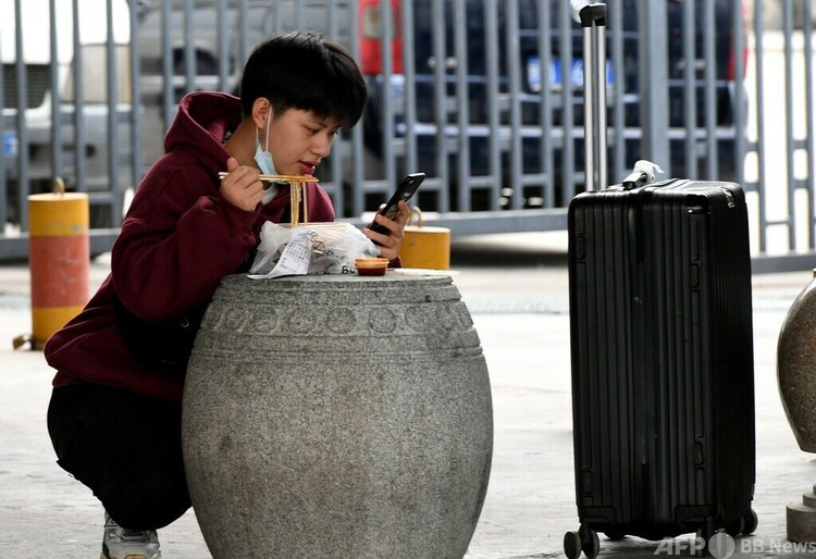 食事をしながらスマホで動画を見る福州市の若者（2021年1月28日撮影、資料写真）。(c)CNS:王東明