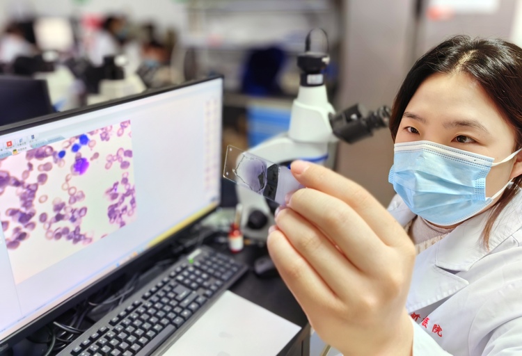 医療ＡＩに読み込ませた骨髄塗抹標本を見せる検査技師（2023年2月14日撮影）。(c)Xinhua News