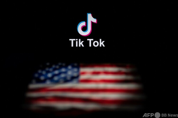 動画投稿アプリ「ティックトック（TikTok）」のロゴと米国国旗（2020年9月14日撮影、資料写真）。(c)NICOLAS ASFOURI : AFP