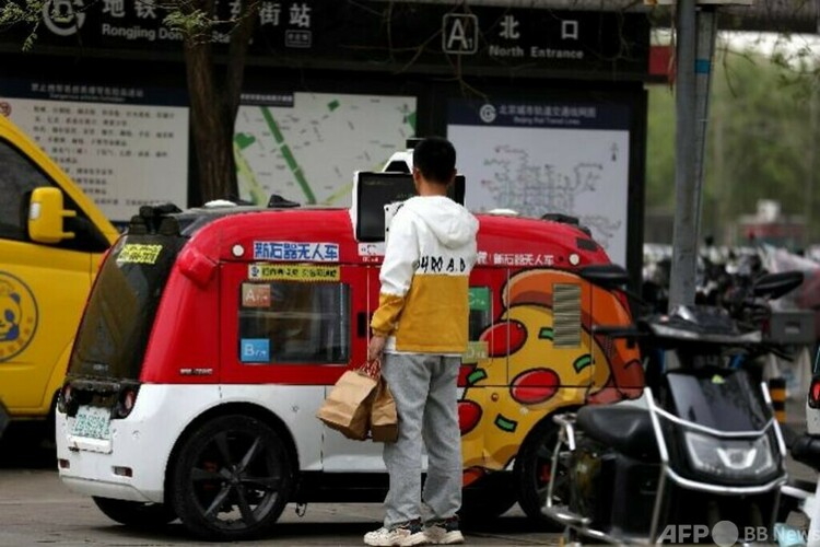 中国の北京市で、「新石器」の無人自動配送車の商品の受け取りや自動販売を体験している市民（2023年4月12日撮影、資料写真）。(c)CNS:趙隽