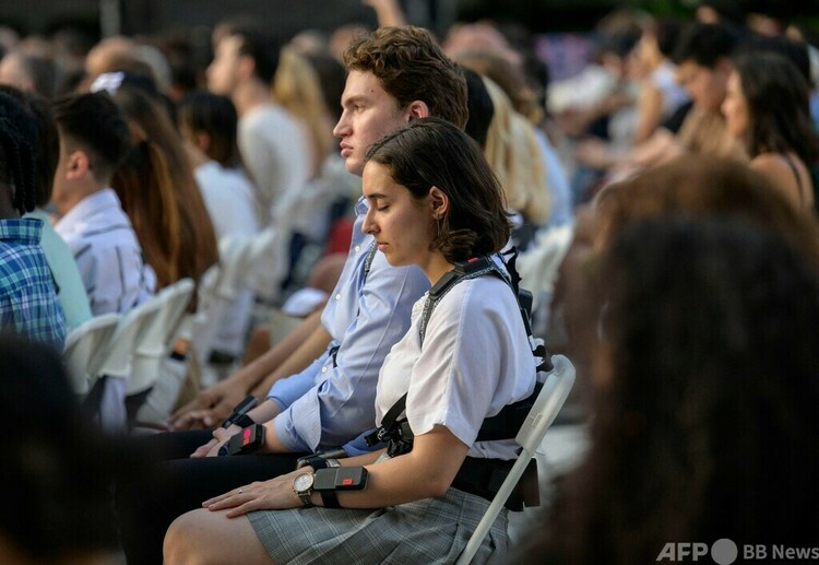 米ニューヨークのリンカーンセンターで、音楽を感知する振動装置を搭載したウェアラブルデバイスを装着し屋外コンサートに参加する人々（2023年7月22日撮影）。(c)ANGELA WEISS / AFP