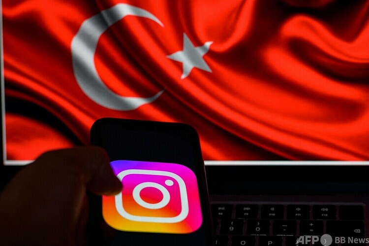 画像共有アプリ、インスタグラムのロゴ。奥はトルコ国旗（2024年8月2日撮影）。(c)Yasin AKGUL : AFP