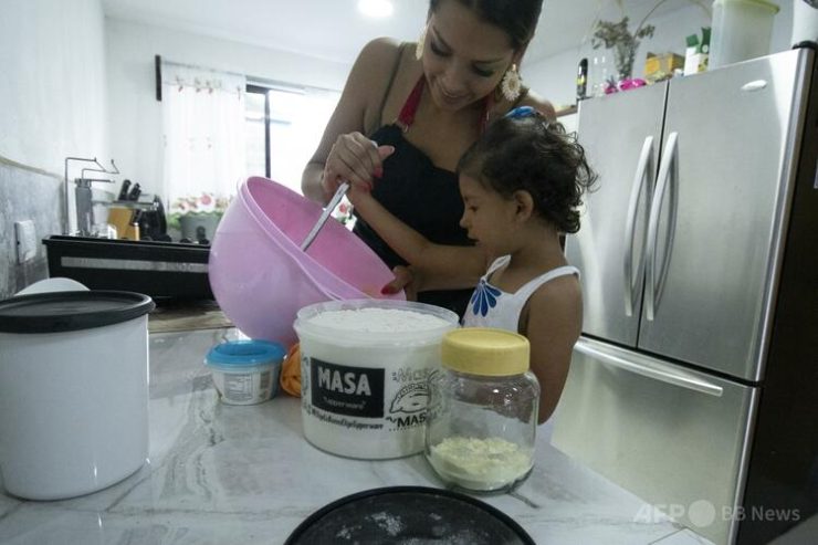 自宅で娘と料理をする女性（2023年7月28日撮影、資料写真）。（c）Ezequiel BECERRA/AFP