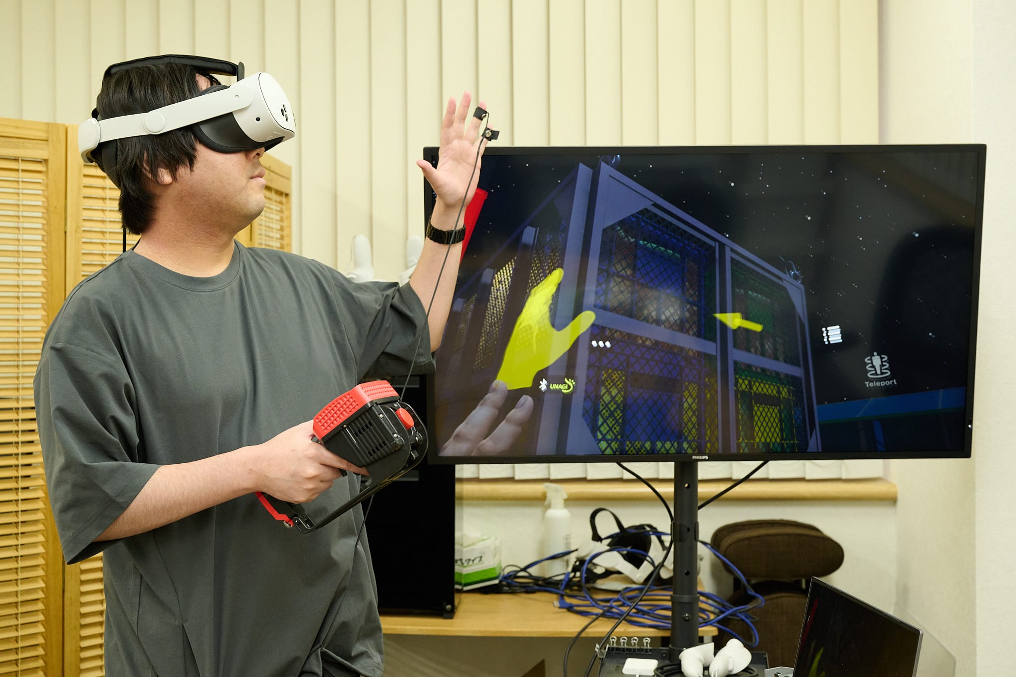 シンフォニア株式会社の「小型移動式クレーンVR訓練システム」とアプリ連動感電デバイス「UNAGI」の連動ソリューションを体験する様子