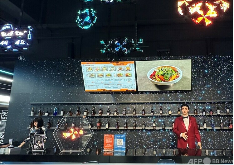 北京・亦庄にあるロボットレストラン「机器人焰究所」。バーカウンターで2体のアンドロイド型ロボットが来客を出迎えている＝2025年8月23日撮影・資料写真(c)CNS:李若晗
