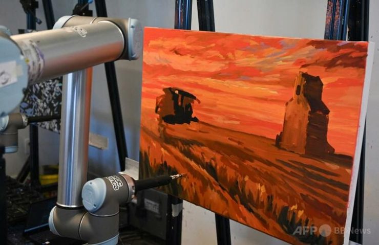 カナダ・モントリオールの企業「アクリルロボティクス」のスタジオで、カンバスに絵を描くAI搭載のロボットアーム(2025年8月12日撮影)。(c)Daphné LEMELIN:AFP