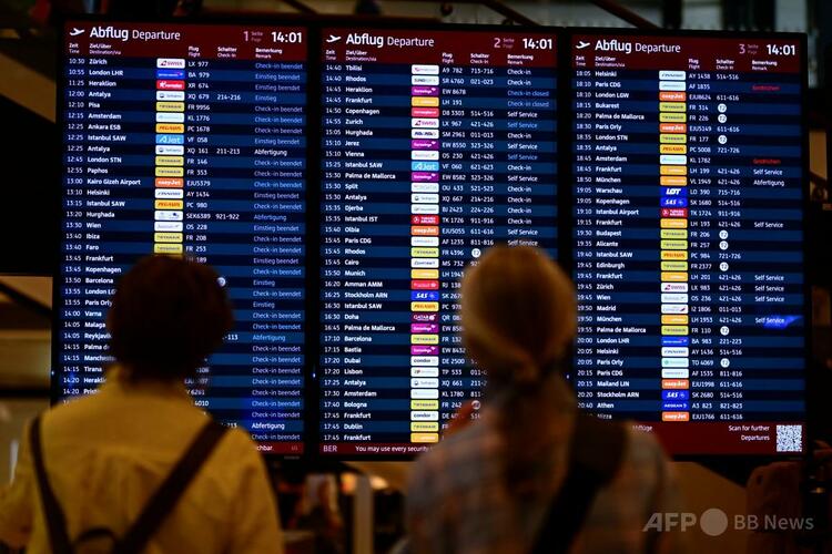 独ベルリン・ブランデンブルク国際空港で、フライト情報表示板を見る乗客（2025年9月20日撮影）。(c)Tobias SCHWARZ/AFP