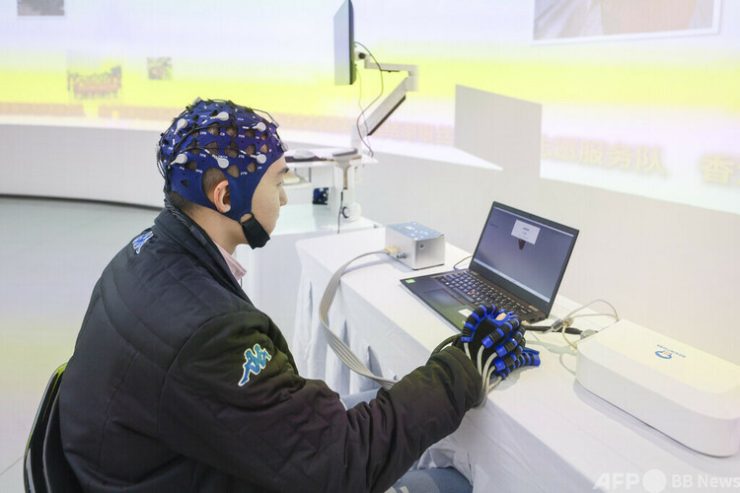 北京市で開催されたスマート介護製品を披露するイベントで、ブレイン・マシン・インターフェースを活用した手のリハビリ訓練システムを体験している人=2025年10月25日撮影・資料写真(c)CNS/賈天勇