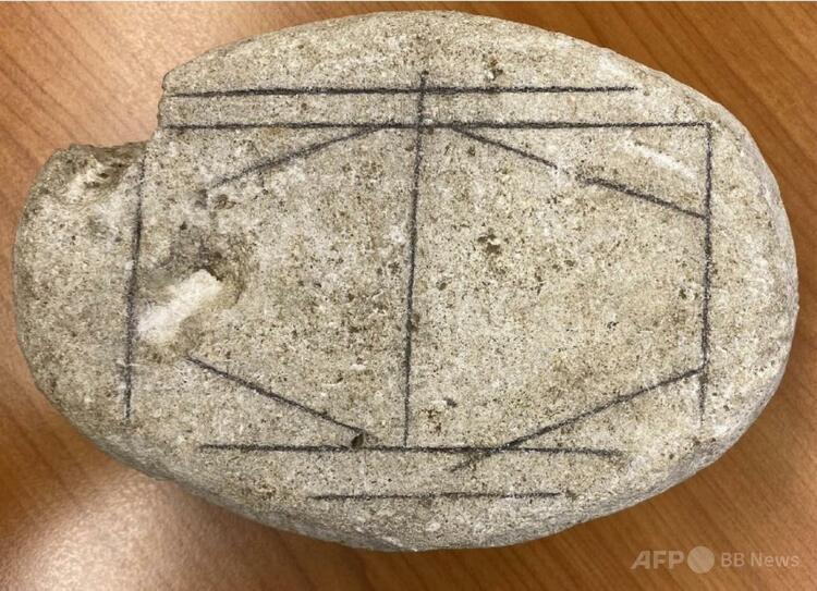 オランダのヘールレンにあるヘット・ロメインス・ミュージアムに展示された、ローマ時代の滑らかな白い石。縦横斜めの線のある石はボードゲームだったと推測された（2026年2月11日公開）。（c）Handout/Antiquity/AFP