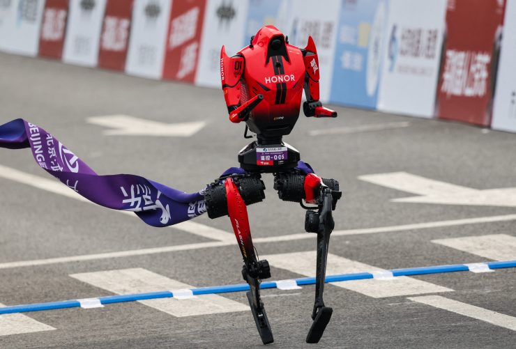 写真は北京で開催されたハーフマラソン大会でのゴールラインを通過するオナーの人型ロボット。REUTERS/Maxim Shemetov