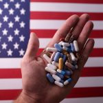 米国旗と錠剤のイメージ写真。2024年6月27日撮影。REUTERS/Dado Ruvic/Illustration