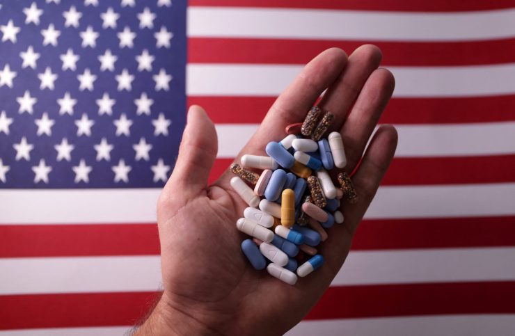米国旗と錠剤のイメージ写真。2024年6月27日撮影。REUTERS/Dado Ruvic/Illustration