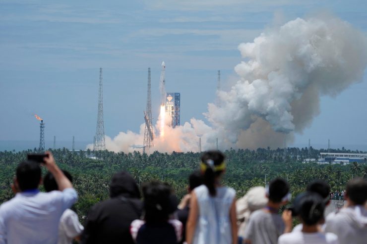 2026年7月10日、中国・海南省の文昌宇宙船発射場から「長征10B」ロケットが打ち上げられ、その後、制御された回収のため沖合のプラットフォームへ垂直に帰還する様子を、人々が眺めている。中国日報(REUTERS経由)