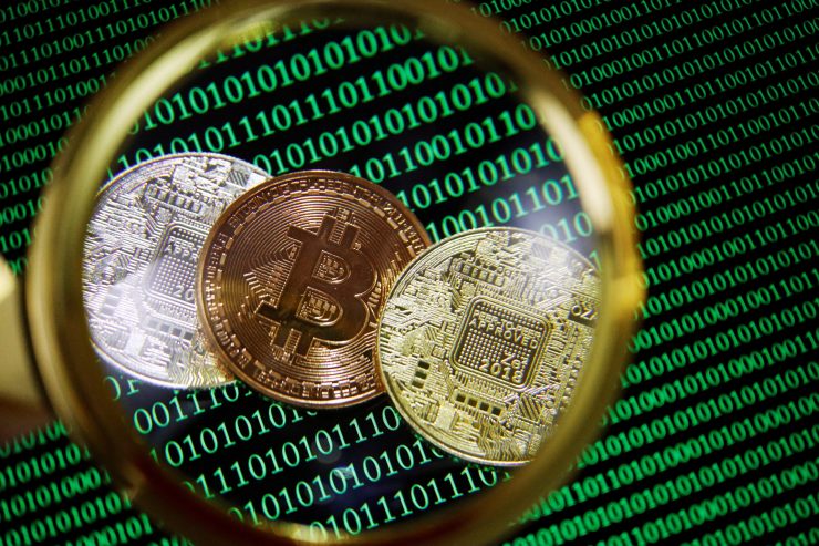 写真は拡大された暗号資産(仮想通貨)のコインと、バイナリーコードのイメージ。2021年9月に撮影。REUTERS/Florence Lo