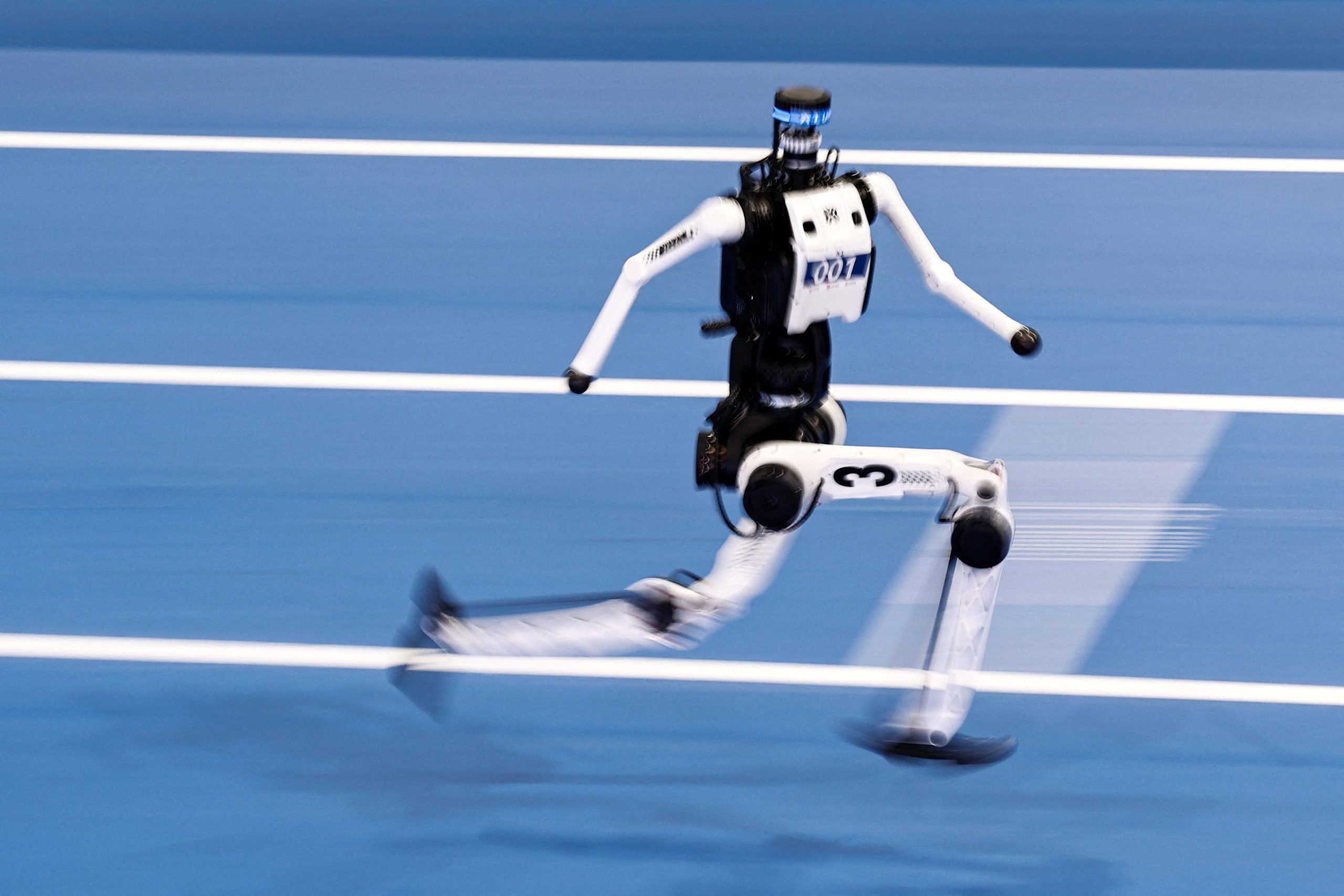 写真は22日の100メートル予選レースで走る人型ロボット。REUTERS/Tingshu Wang