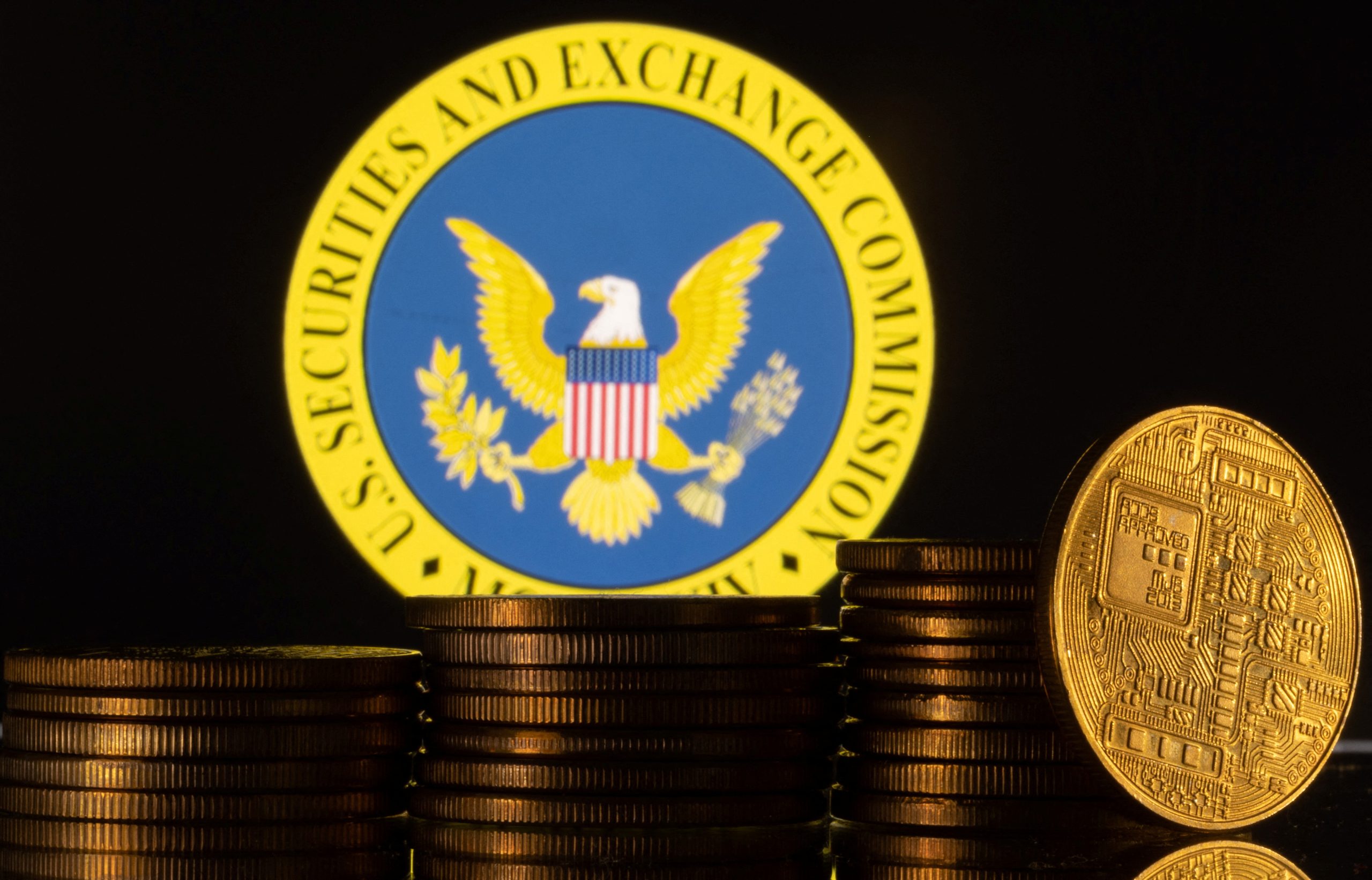 写真は米証券取引委員会(SEC)のロゴと仮想通貨のイメージ。2023年6月に撮影。REUTERS/Dado Ruvic