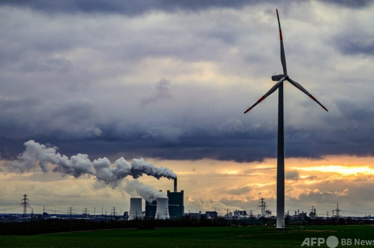 ドイツ北東部ハレのシュコーパウ火力発電所（画面奥）と風力タービン（2024年1月4日撮影、資料写真）。(c)John MACDOUGALL : AFP