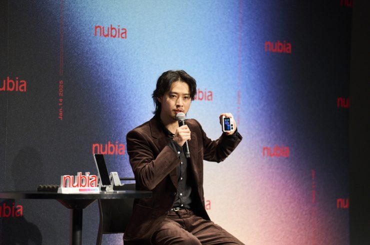 折り畳み式スマホ「nubia Flip 2」を持つ山崎賢人さん(2025年1月14日撮影)。(c)Xinhua News