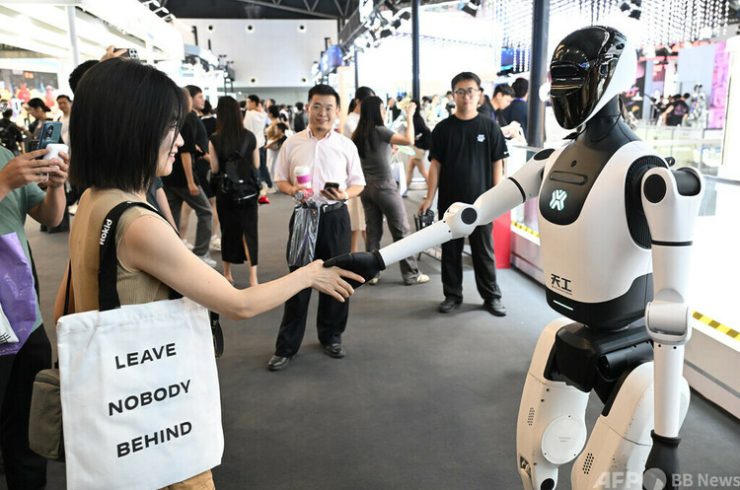 上海で開催された世界人工知能大会にて人型ロボットと来場者が握手する様子＝2025年7月26日撮影・飼料写真(c)CNS:田雨昊