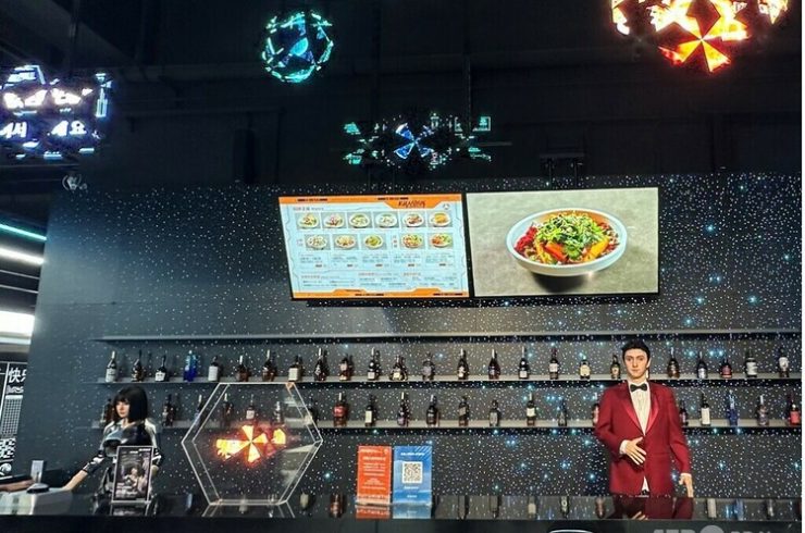 北京・亦庄にあるロボットレストラン「机器人焰究所」。バーカウンターで2体のアンドロイド型ロボットが来客を出迎えている＝2025年8月23日撮影・資料写真(c)CNS:李若晗