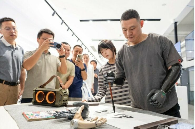 浙江強脳科技有限公司の展示ホールで、スマート義手を使って筆文字を書く製品体験官=2025年9月17日撮影・資料写真(c)CNS:翟慧勇