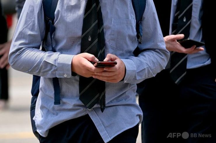 オーストラリア・メルボルンで携帯端末を利用する若者たち(2024年11月28日撮影)。(c)William WEST:AFP