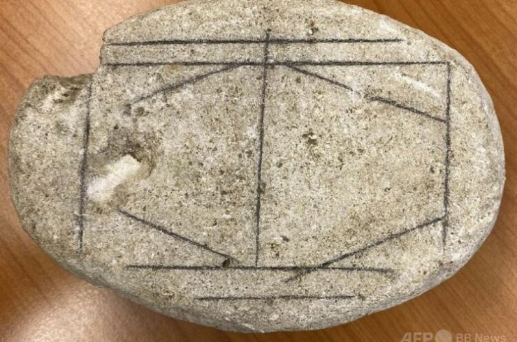 オランダのヘールレンにあるヘット・ロメインス・ミュージアムに展示された、ローマ時代の滑らかな白い石。縦横斜めの線のある石はボードゲームだったと推測された（2026年2月11日公開）。（c）Handout/Antiquity/AFP