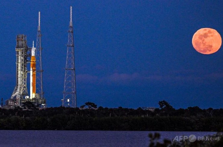 米フロリダ州ケネディ宇宙センターで、有人月探査ミッションのアルテミスIIスペース・ローンチ・システムロケットとオリオン宇宙船の発射台から見える満月（2026年2月1日撮影）。（c）Miguel J. Rodriguez Carrillo/AFP